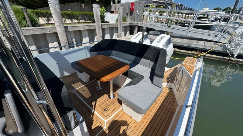 Slide: The Image of Luxurious 2025 Nimbus T9 boat interior with wooden deck and cushioned seating. - 22