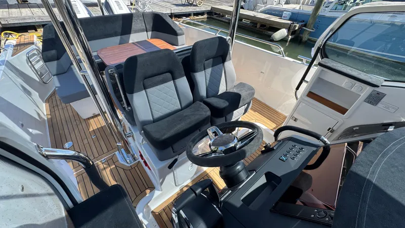 Slide: The Image of Interior of a 2025 Nimbus T9 boat with modern seating and steering wheel. - 25
