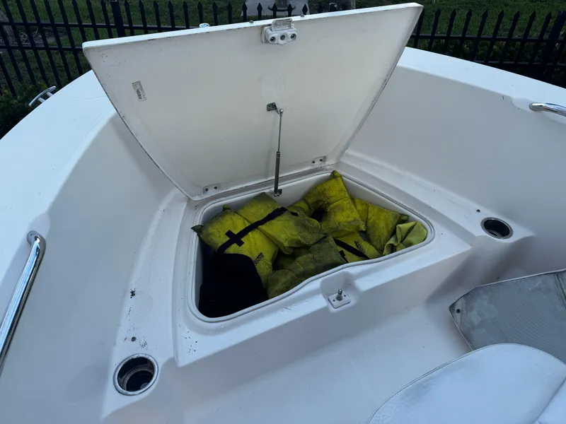 Slide: The Image of 2018 Robalo R180 Center Console boat storage compartment, white interior, open hatch. - 15