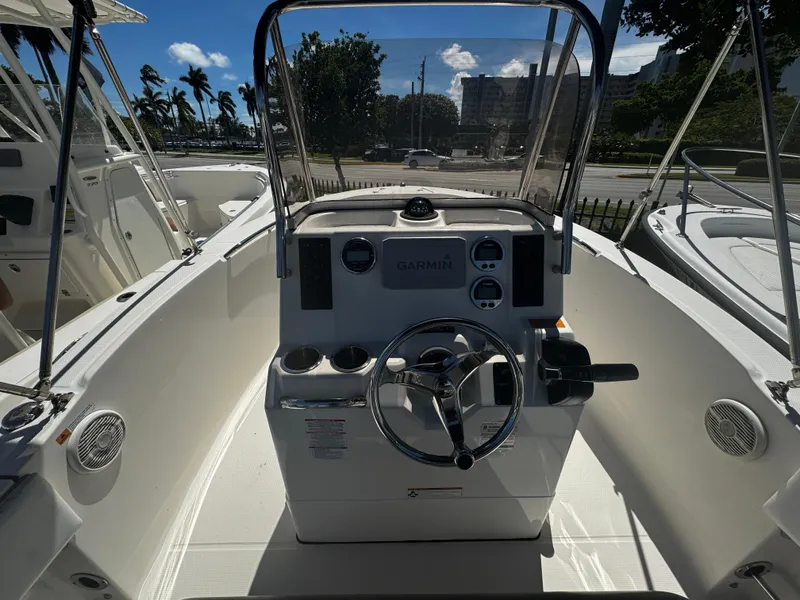 Slide: The Image of 2018 Robalo R180 Center Console boat with Garmin navigation, docked under a canopy. - 3