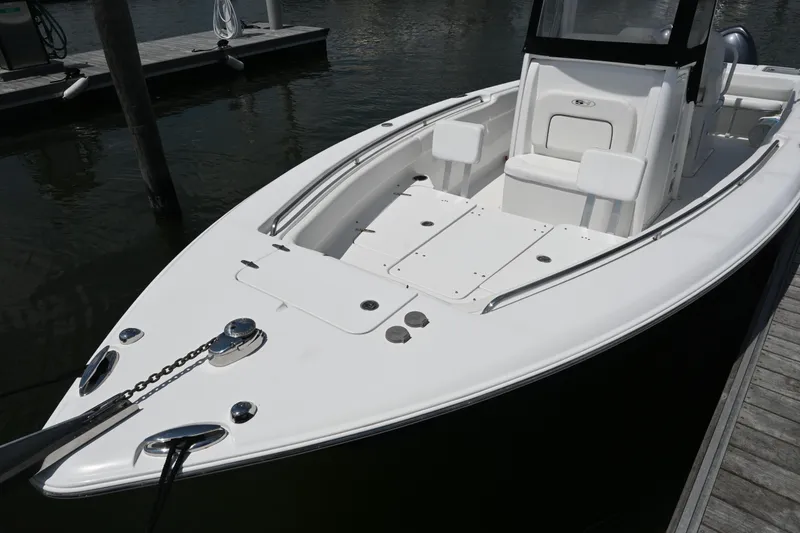 Slide: The Image of 2013 Sea Hunt Gamefish 27 boat docked, showcasing sleek design and spacious deck. - 16