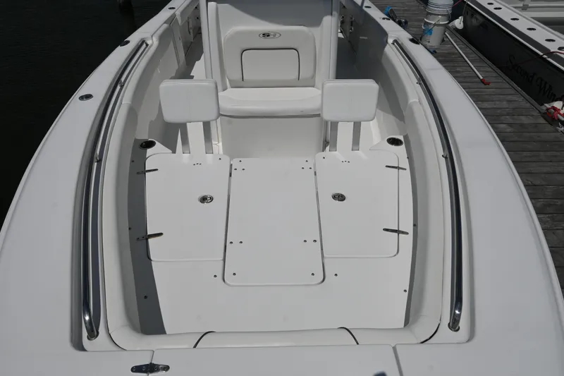 Slide: The Image of 2013 Sea Hunt Gamefish 27 boat interior with white seating and storage compartments. - 17