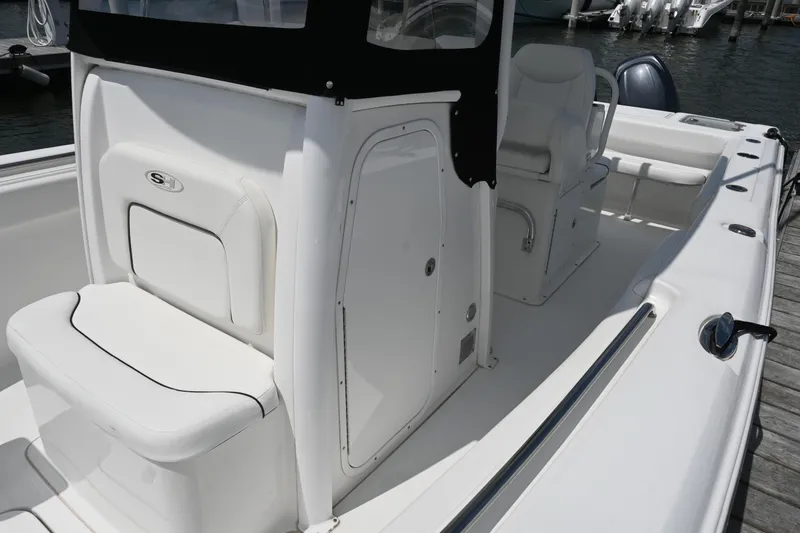 Slide: The Image of 2013 Sea Hunt Gamefish 27 boat interior with seating and console, docked at marina. - 25