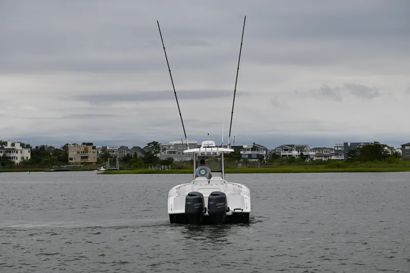 Slide: The Image of 2013 Sea Hunt Gamefish 27 boat on water, overcast sky, coastal homes in background. - 3