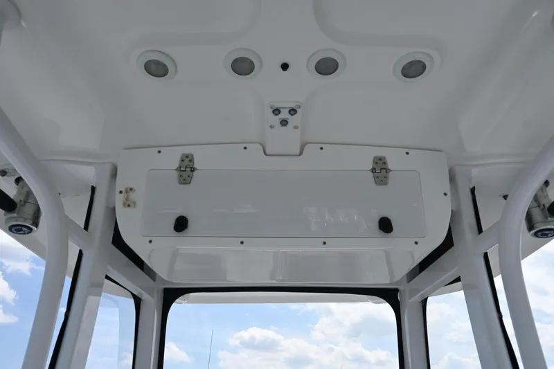 Slide: The Image of 2013 Sea Hunt Gamefish 27 boat interior ceiling with storage compartment and lights. - 30
