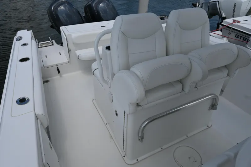 Slide: The Image of 2013 Sea Hunt Gamefish 27 boat interior with dual white seats and twin engines. - 32