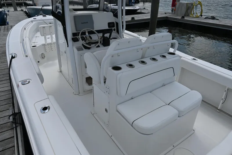Slide: The Image of 2013 Sea Hunt Gamefish 27 boat interior with seating and steering console at dock. - 35