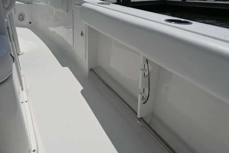 Slide: The Image of 2013 Sea Hunt Gamefish 27 boat interior, featuring sleek white design and rod holders. - 38