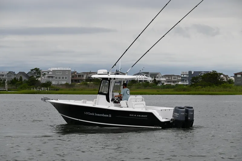 Slide: The Image of 2013 Sea Hunt Gamefish 27 boat on water, overcast sky, coastal homes in background. - 5