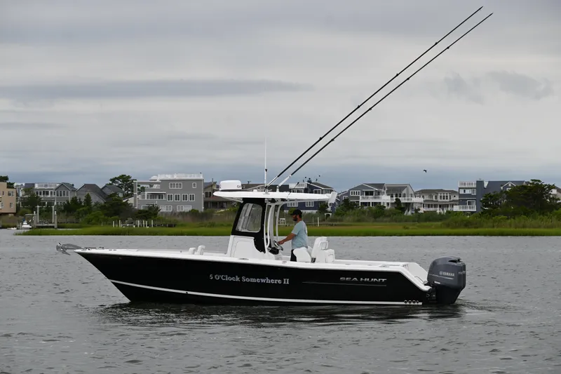 Slide: The Image of 2013 Sea Hunt Gamefish 27 boat on water, overcast sky, coastal homes in background. - 6