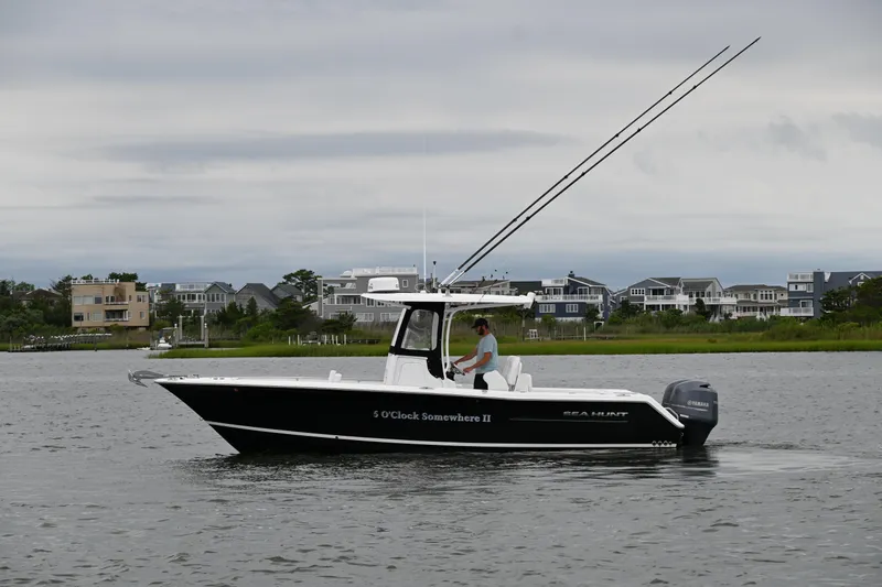 Slide: The Image of 2013 Sea Hunt Gamefish 27 boat on water, coastal homes in background. - 7