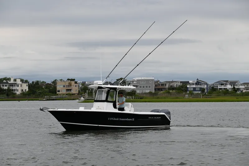 Slide: The Image of 2013 Sea Hunt Gamefish 27 boat cruising on a calm waterway near residential area. - 8