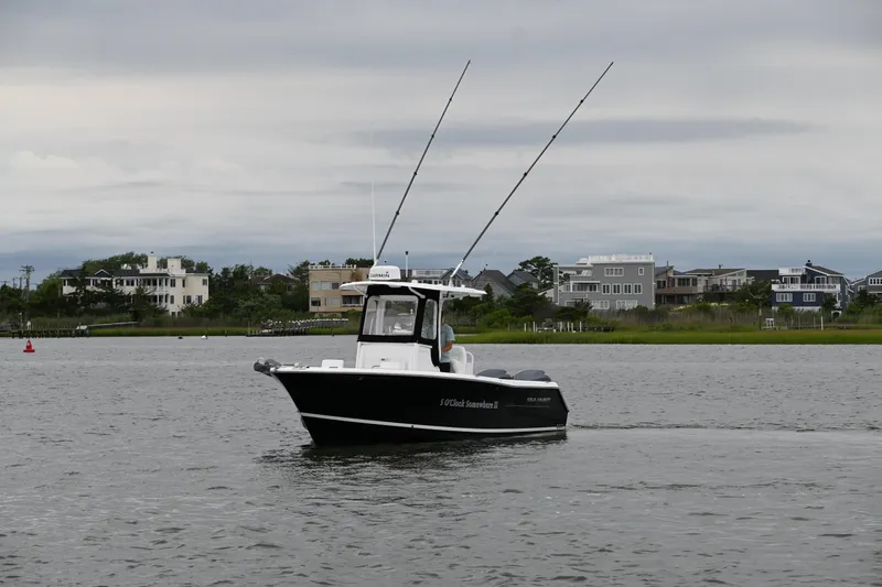 Slide: The Image of 2013 Sea Hunt Gamefish 27 boat on calm water near residential shoreline. - 9