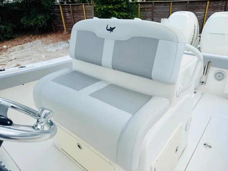 Slide: The Image of 2018 Mako 284 CC boat interior with dual seating and steering wheel. - 11