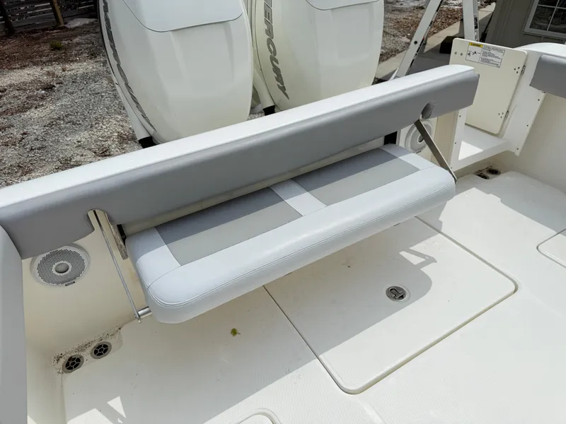 Slide: The Image of 2018 Mako 284 CC boat with foldable bench seat and dual outboard engines. - 16