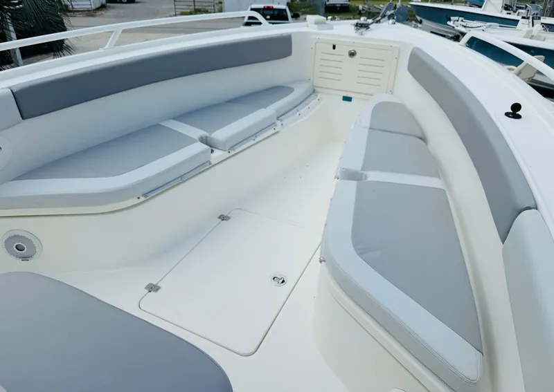 Slide: The Image of 2018 Mako 284 CC boat interior with cushioned seating and storage compartments. - 8