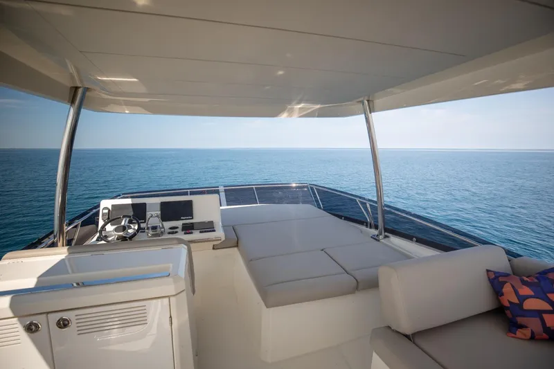 Slide: The Image of Flybridge view of 2020 Prestige 590 Cruiser, featuring luxurious seating and ocean backdrop. - 12