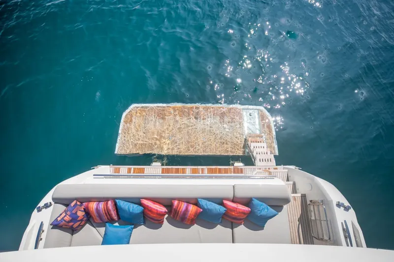 Slide: The Image of Luxurious 2020 Prestige 590 Flybridge Cruiser with colorful cushions, overlooking sparkling blue water. - 13