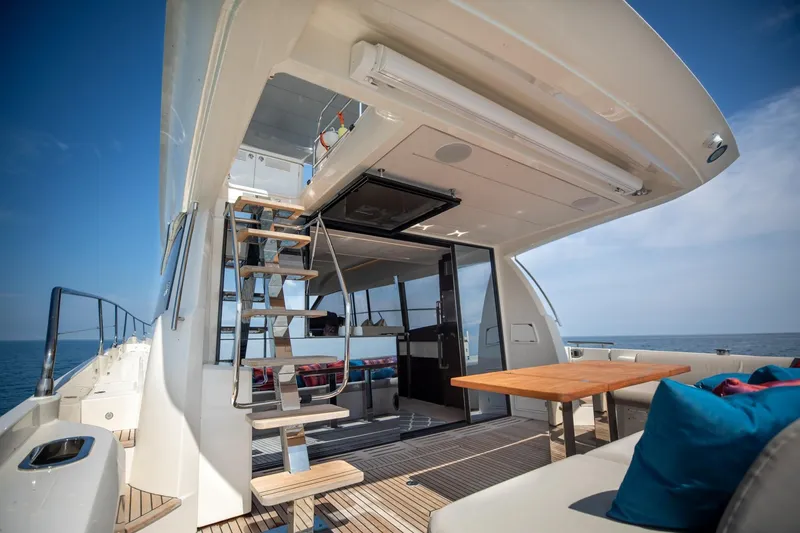 Slide: The Image of Prestige 590 Flybridge Cruiser 2020, luxurious deck view with seating and ocean backdrop. - 18