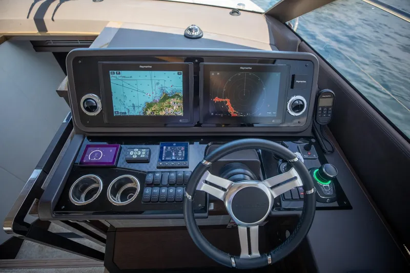 Slide: The Image of Helm of 2020 Prestige 590 Flybridge Cruiser with navigation screens and controls. - 26