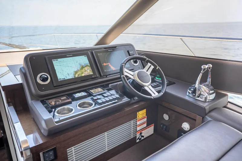 Slide: The Image of Helm of 2020 Prestige 590 Flybridge Cruiser with navigation screens and controls. - 27