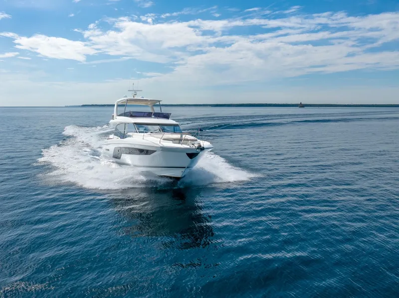 Slide: The Image of 2020 Prestige 590 Flybridge Cruiser sailing on open sea under clear blue sky. - 3