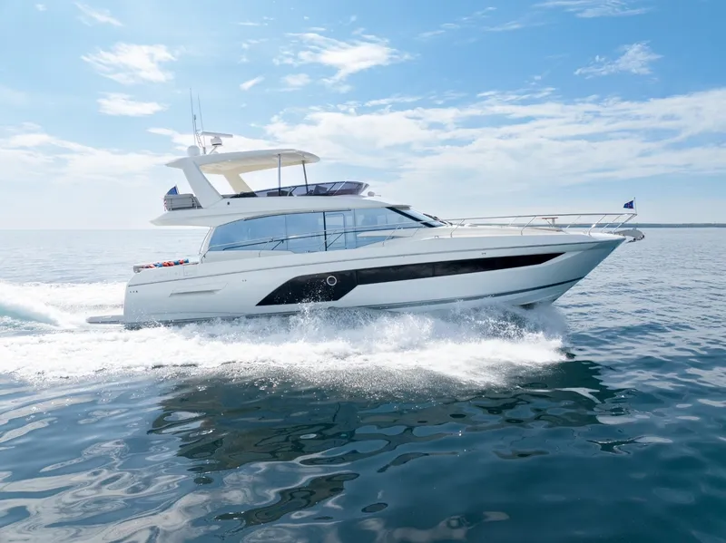 Slide: The Image of 2020 Prestige 590 Flybridge Cruiser sailing on open water under clear skies. - 4