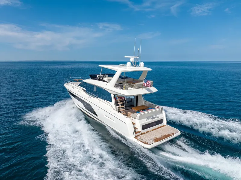 Slide: The Image of 2020 Prestige 590 Flybridge Cruiser sailing on open sea under clear blue sky. - 7