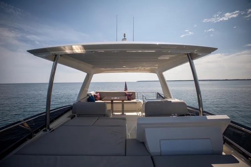Slide: The Image of 2020 Prestige 590 Flybridge Cruiser on calm sea, featuring spacious deck and seating area. - 8