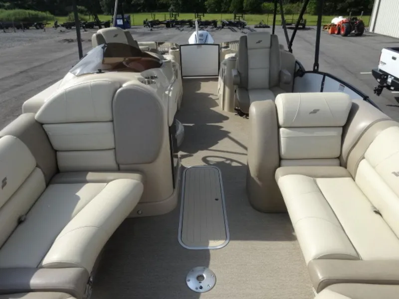 Slide: The Image of 2018 Starcraft MX23L pontoon boat interior with beige seating and spacious layout. - 3