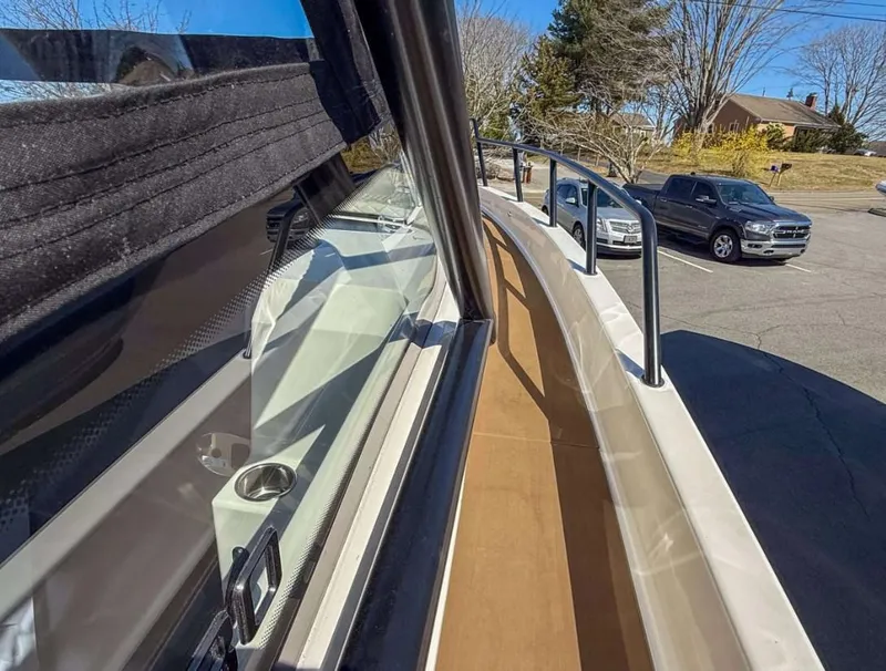 Slide: The Image of 2025 Navan S30 boat deck view with parked cars in the background. - 11