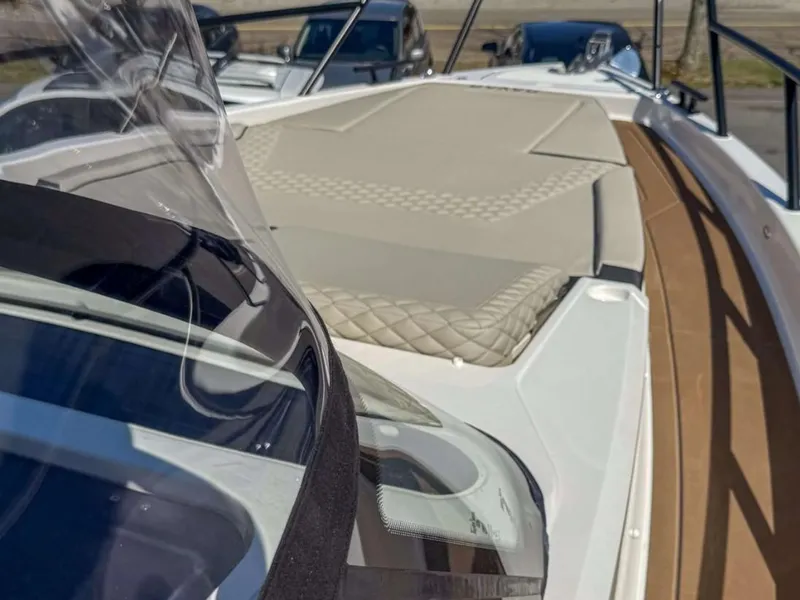 Slide: The Image of 2025 Navan S30 boat with sleek design and cushioned deck, docked outdoors. - 12