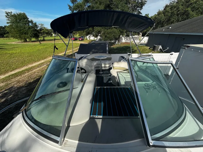 Slide: The Image of 2005 Sea Ray 260 Sundancer boat with open deck and canopy, parked outdoors. - 33