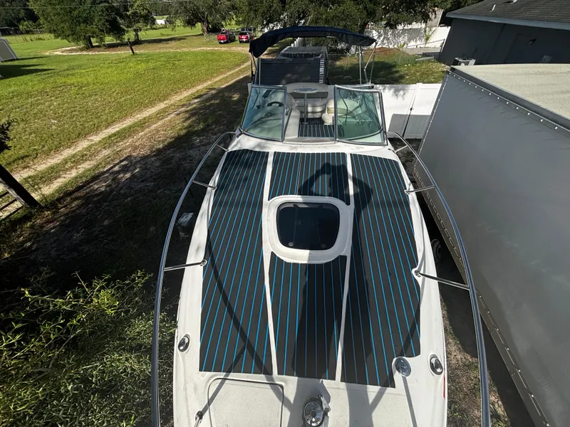 Slide: The Image of 2005 Sea Ray 260 Sundancer boat with striped deck, parked outdoors. - 34