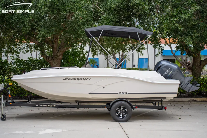 Slide: The Image of 2024 Starcraft SVX 191 OB boat on trailer with Yamaha outboard motor, parked outdoors. - 0