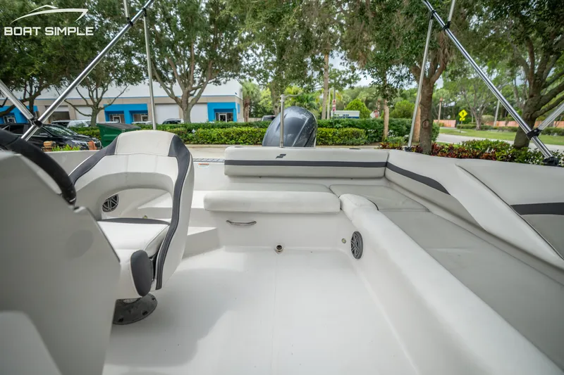 Slide: The Image of 2024 Starcraft SVX 191 OB boat interior with seating and steering wheel, surrounded by trees. - 13