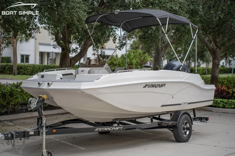 Slide: The Image of 2024 Starcraft SVX 191 OB boat on trailer, parked outdoors with canopy. - 2