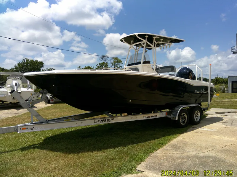 Slide: The Image of 2023 NauticStar 231 Hybrid boat on trailer under blue sky. - 12