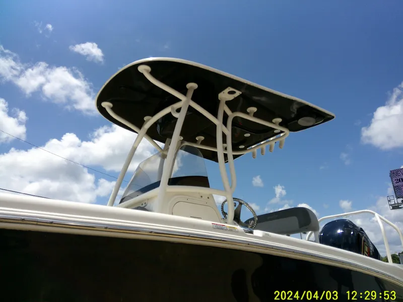 Slide: The Image of 2023 NauticStar 231 Hybrid boat under clear blue sky with T-top. - 13