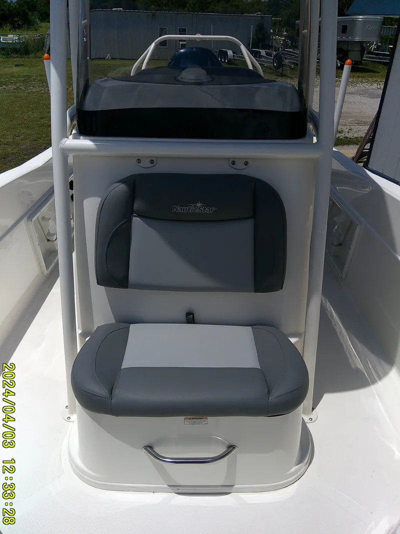 Slide: The Image of 2023 NauticStar 231 Hybrid boat seat with gray upholstery and console. - 25