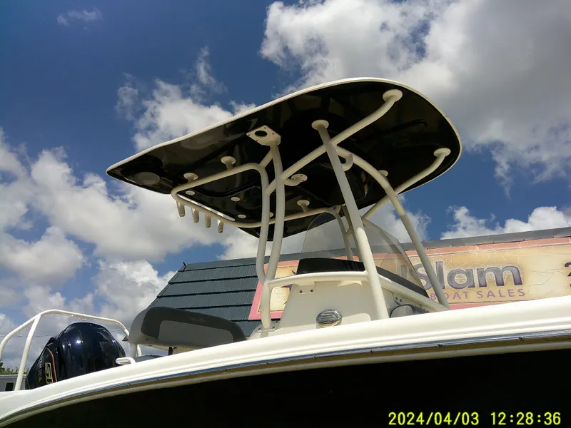 Slide: The Image of 2023 NauticStar 231 Hybrid boat with T-top under a blue sky. - 3