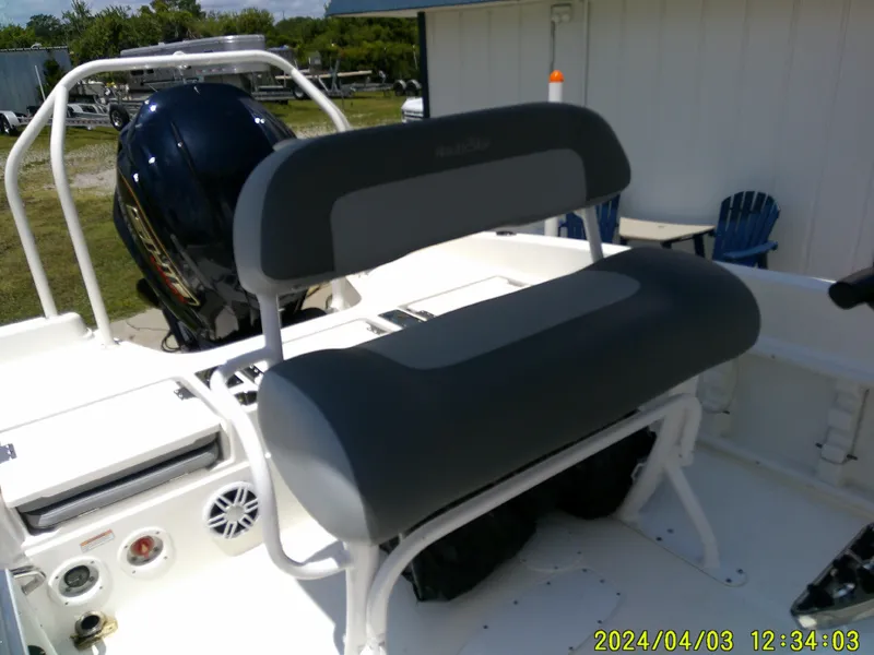 Slide: The Image of 2023 NauticStar 231 Hybrid boat interior with seating and engine, outdoor setting. - 31