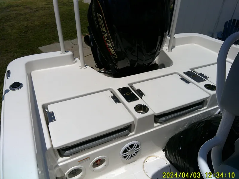 Slide: The Image of 2023 NauticStar 231 Hybrid boat interior with storage compartments and motor. - 32