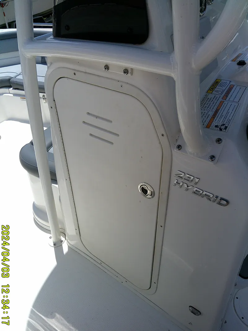 Slide: The Image of 2023 NauticStar 231 Hybrid boat console with storage compartment and branding. - 33
