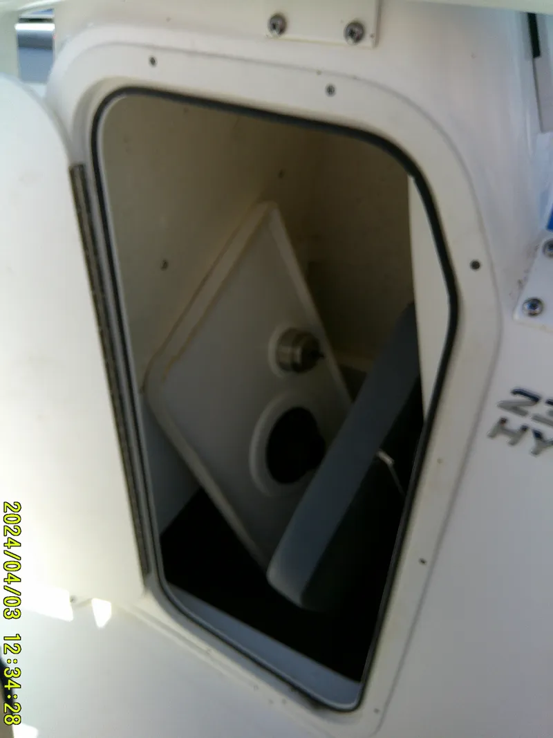 Slide: The Image of 2023 NauticStar 231 Hybrid boat storage compartment with open hatch. - 34