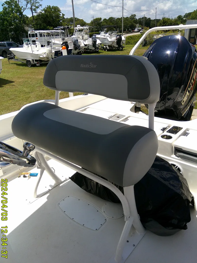 Slide: The Image of 2023 NauticStar 231 Hybrid boat seat with gray upholstery, outdoor setting. - 35