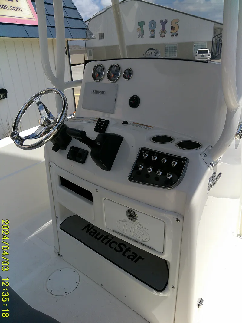 Slide: The Image of 2023 NauticStar 231 Hybrid boat console with steering wheel and controls. - 40