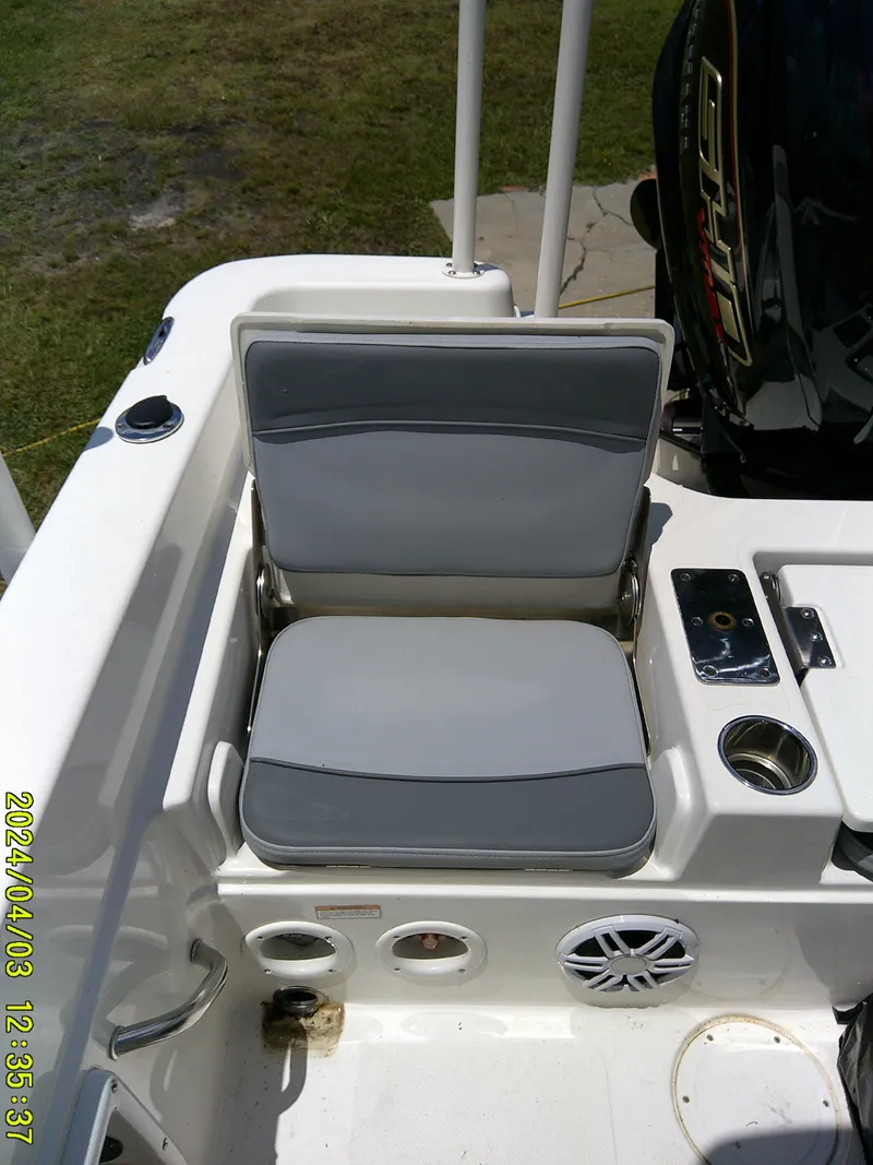 Slide: The Image of 2023 NauticStar 231 Hybrid boat seat with gray cushions and nearby controls. - 42