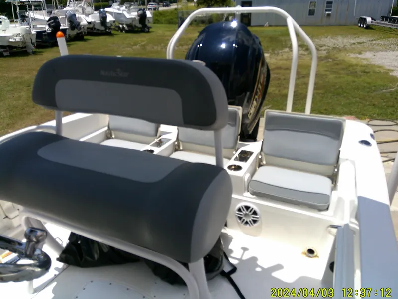 Slide: The Image of 2023 NauticStar 231 Hybrid boat interior with seating and engine, displayed outdoors. - 46