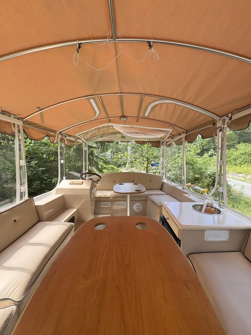 Slide: The Image of Interior of 2008 Duffy Snug Harbor 18 boat with tan seating and wooden table. - 4